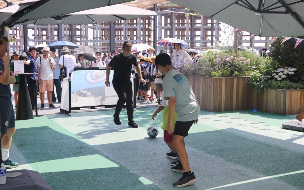 Andy Burnham kicks a football at a City promotional event in Osaka in June 2025