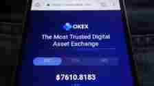 The website for OKEx is shown on a smartphone.