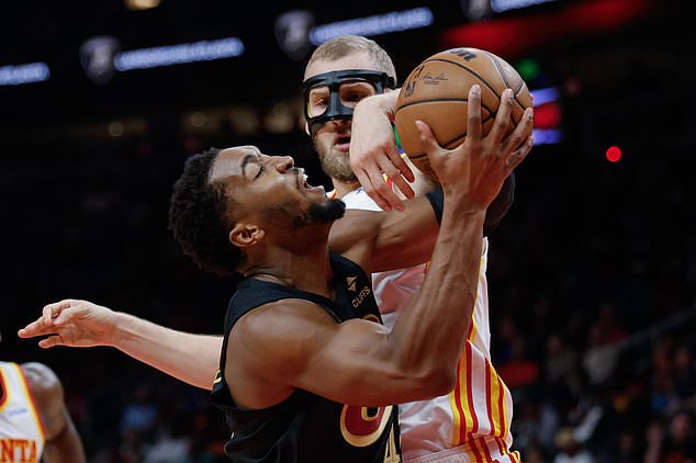 Cleveland Cavaliers guard Donovan Mitchell, left, is fouled by Atlanta Hawks center Jock Landale, right, during the first half of an NBA basketball game, Thursday, Oct. 29, 2026, in Atlanta. (AP Photo/Erik S. Lesser)
