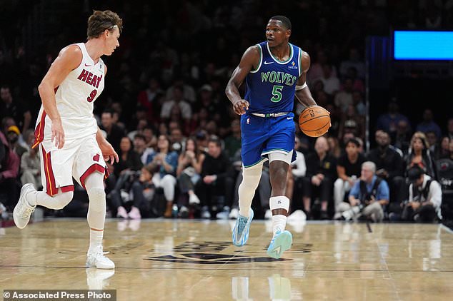 Minnesota Timberwolves guard Anthony Edwards (5) dribbles down court pursued by Miami Heat guard Pelle Larsson (9) during the second half of an NBA basketball game, Wednesday, Oct. 21, 2026, in Miami. (AP Photo/Rebecca Blackwell)