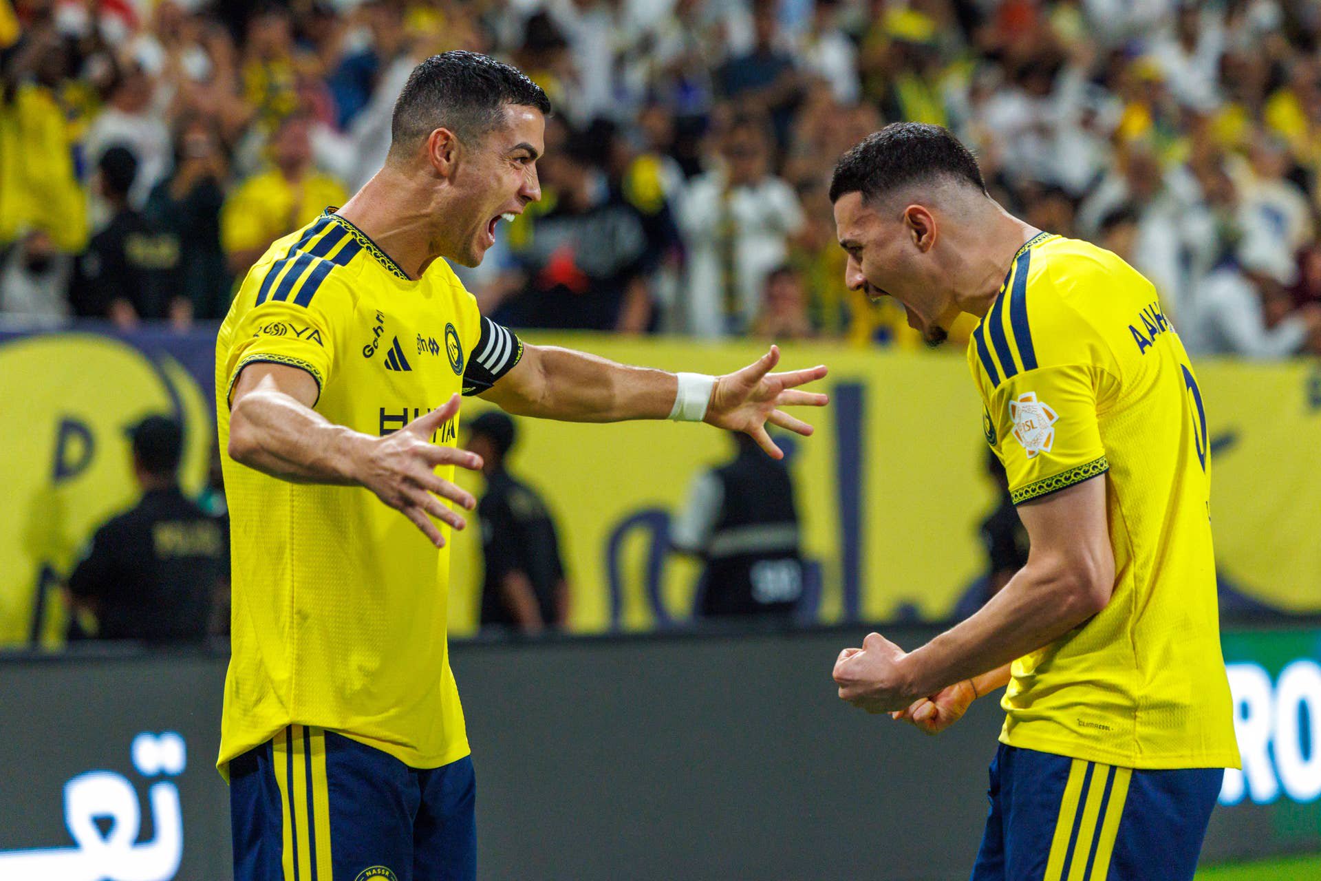 Cristiano Ronaldo jubelt im gelben Al-Nassr-Trikot lautstark gemeinsam mit seinem Teamkollegen Ângelo auf dem Spielfeld.