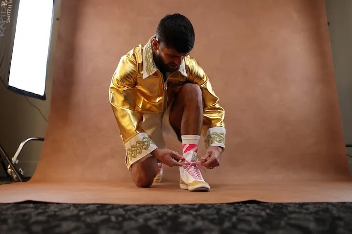 Joe Cordina laces his boots at a media day in November 2025
