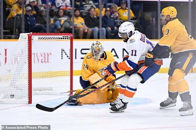New York Islanders left wing Anthony Duclair (11) scores on Nashville Predators goaltender Juuse Saros, left, and defenseman Jayden Struble (3) during the first period of an NHL hockey game Tuesday, Oct. 27, 2026, in Nashville, Tenn. (AP Photo/John Amis)