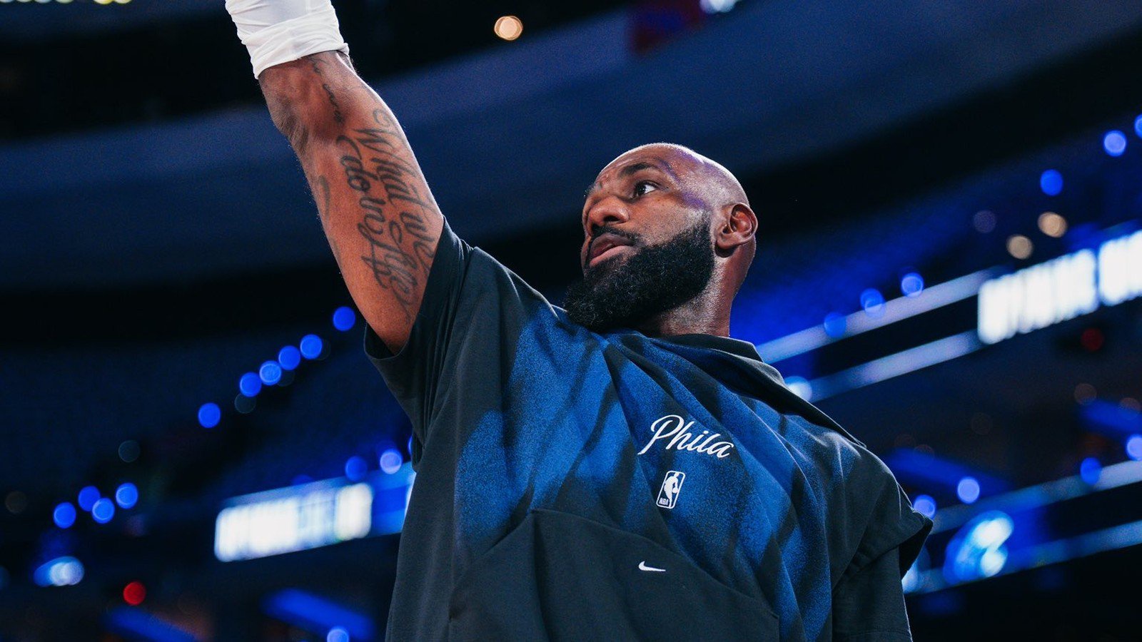 LeBron James com barba e camiseta 'Phila', braço direito tatuado erguido em quadra