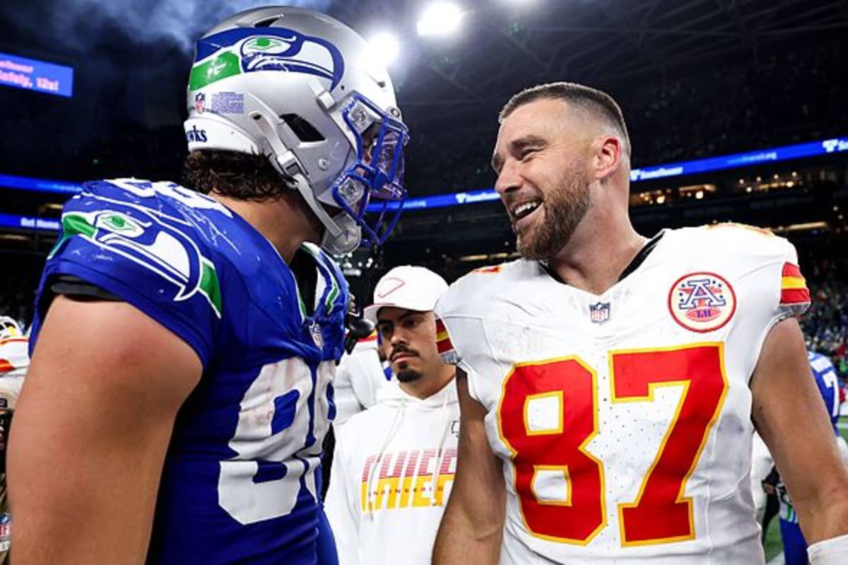 SEATTLE, WASHINGTON - OCTOBER 25: Travis Kelce #87 of the Kansas City Chiefs speaks with AJ Barner #88 of the Seattle Seahawks a