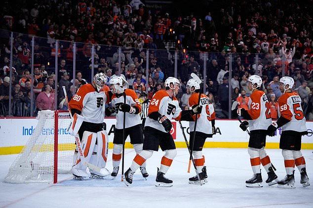 Philadelphia Flyers players celebrate after winning an NHL hockey game against the Ottawa Senators Saturday, Oct. 17, 2026, in Philadelphia. (AP Photo/Matt Slocum)