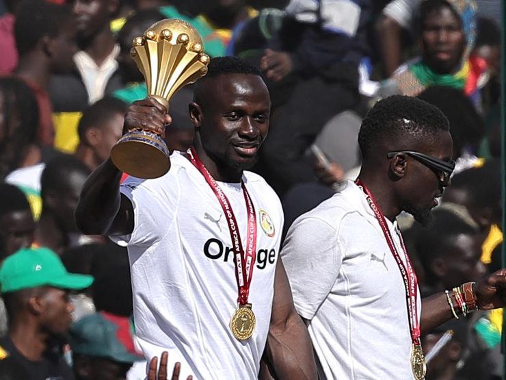 Senegal’s Sadio Mane celebrates with the trophy on the bus during the victory parade