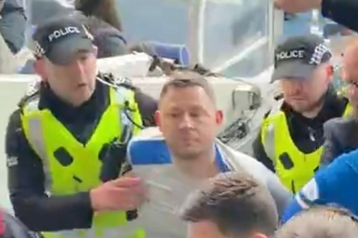 Marc Spence dragged away from the pitch at Ibrox by police
