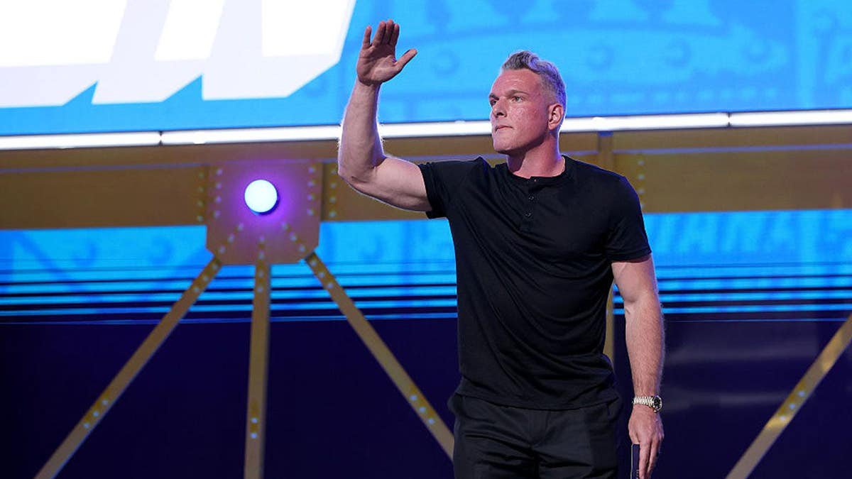 Pat McAfee salutes on stage during the 2026 NFL Draft at Acrisure Stadium.