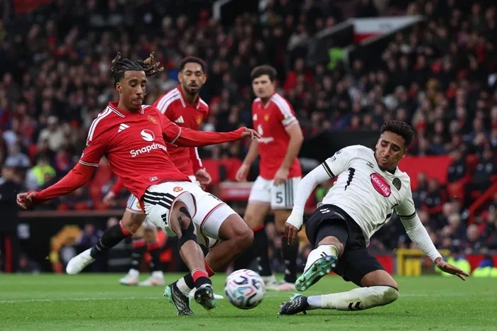 Bournemouth defender James Hill, right, blocks a shot from Manchester United's Leny Yoro during the English Premier League match at Old Trafford. 