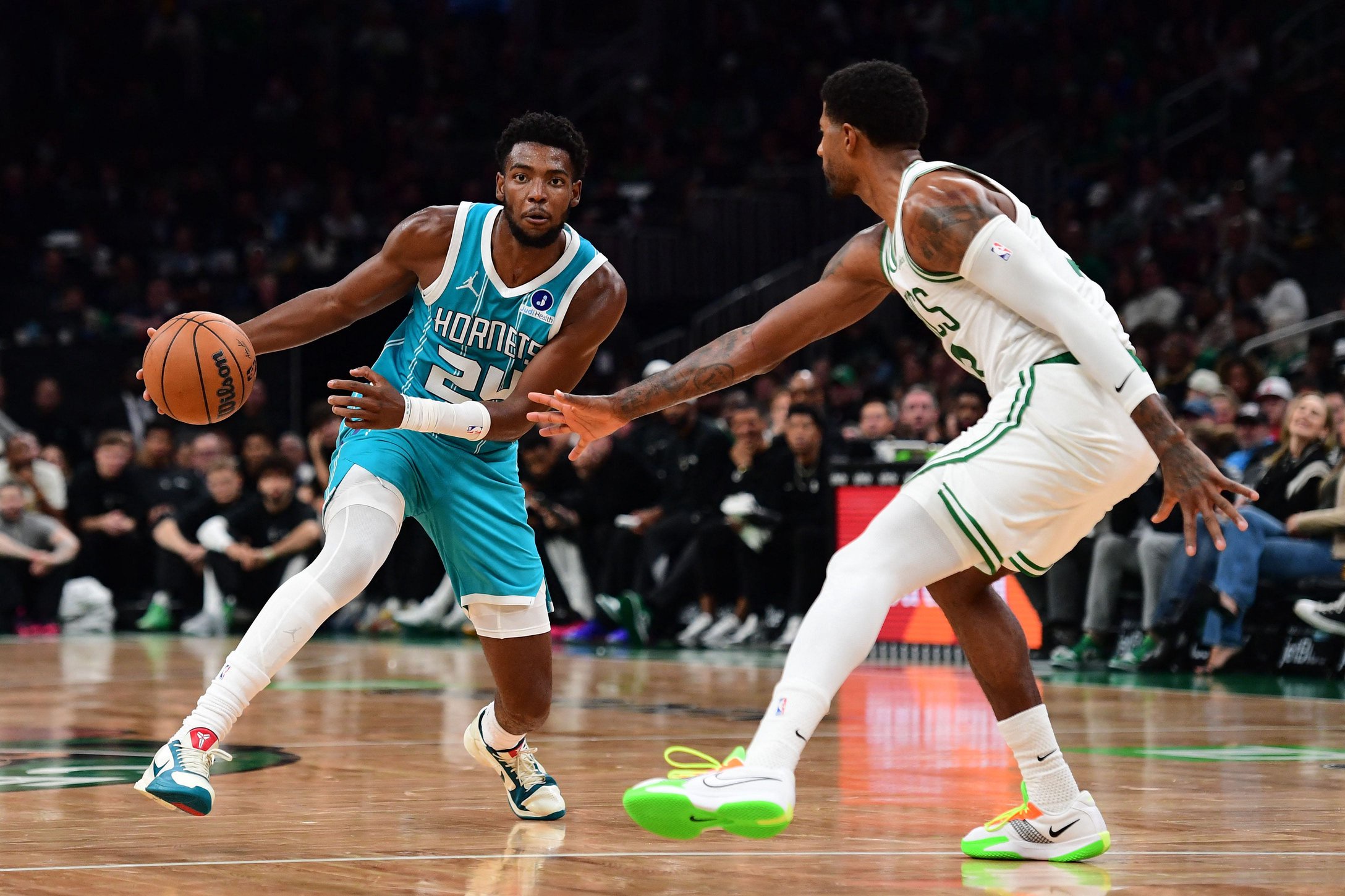 Oct 14, 2026; Boston, Massachusetts, USA;  Charlotte Hornets forward Brandon Miller (24) controls the ball while Boston Celtics forward Paul George (13) defends during the second half at TD Garden. Mandatory Credit: Bob DeChiara-Imagn Images