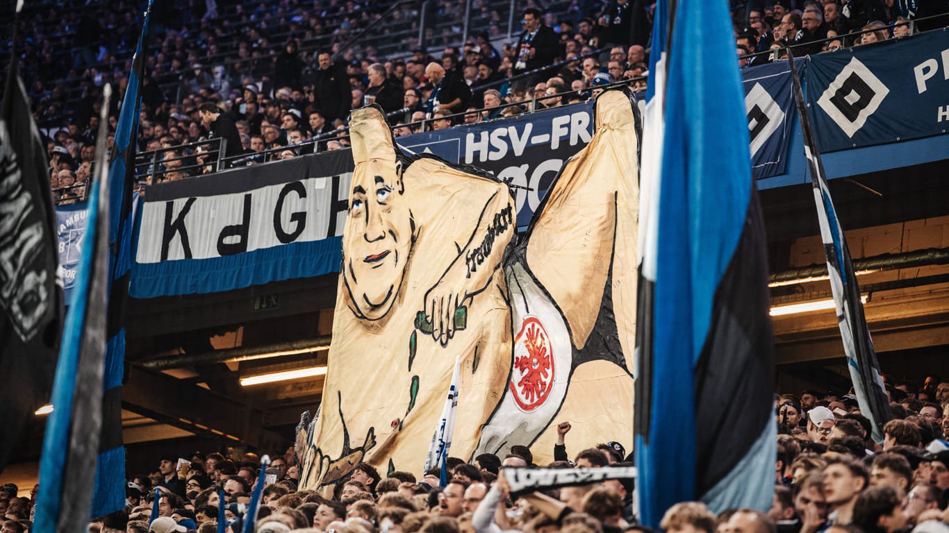 Die HSV-Fans zeigen ein Transparent: Darauf ist ein Frankfurter in Unterwäsche und mit Würstchen in der Hand zu sehen.