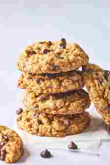 A stack of an oatmeal chocolate chip cookie recipe after baking on white background