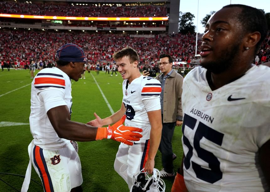 Auburn wide receiver Bryce Cain celebrates with kicker Alex McPherson and offensive lineman Kenneth McManus IV following an upset win over Georgia on Saturday.