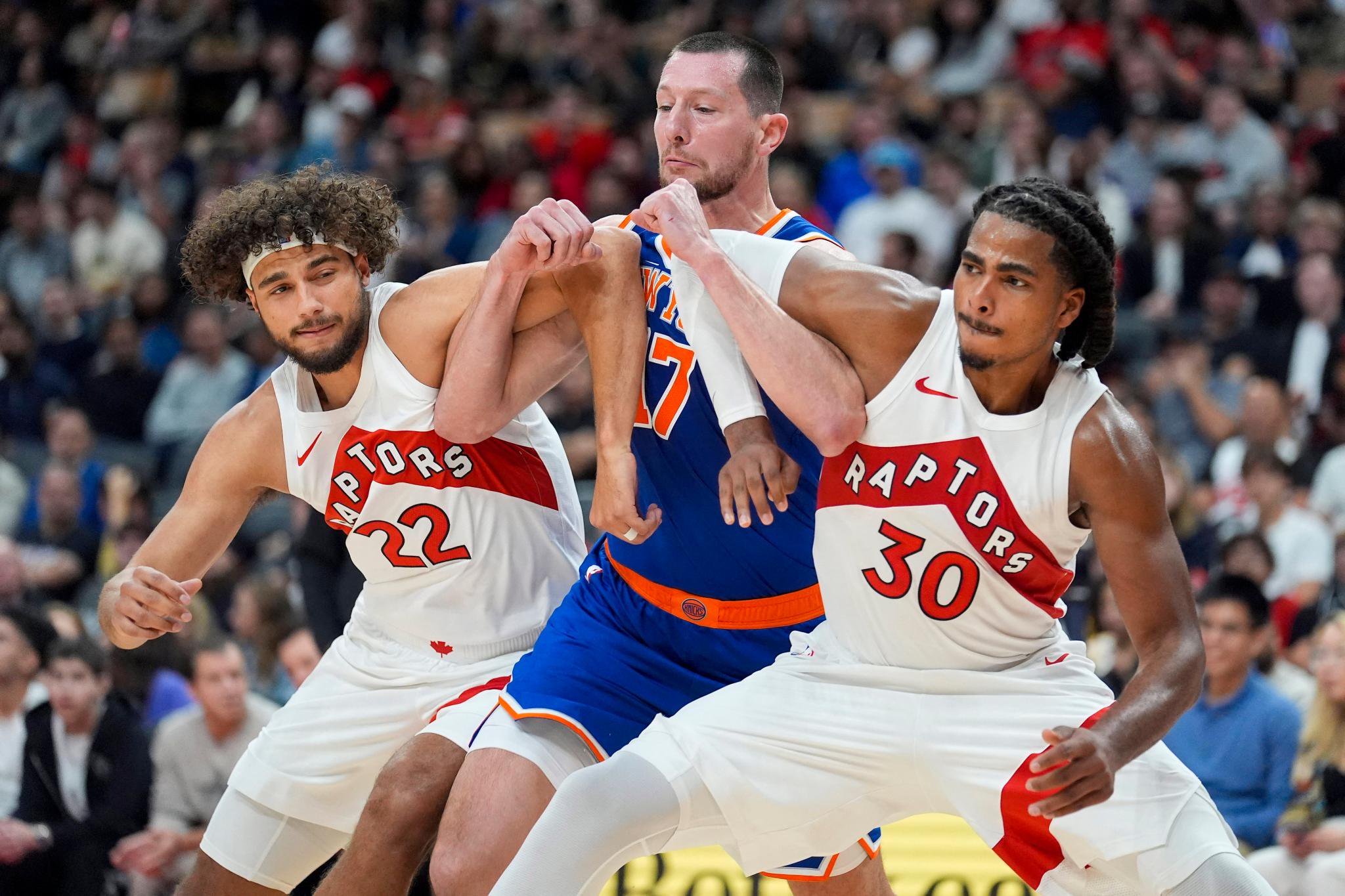Knicks center Drew Eubanks (17) battles for position against Toronto Raptors forward Allen Graves (22) and forward Collin Murray-Boyles (30) during the first half of an NBA basketball game at Scotiabank Arena in Toronto, Ontario, Tuesday, Oct. 13, 2026.