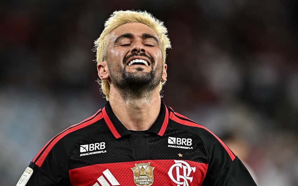 Jogador do Flamengo com cabelo loiro celebra vitória, camisa rubro-negra com escudo.