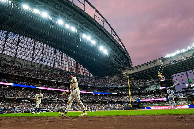 Milwaukee Brewers players return to the dugout during the sixth inning of Game 2 of baseball's National League Championship Series between the Milwaukee Brewers and the Los Angeles Dodgers, Monday, Oct. 12, 2026, in Milwaukee. (AP Photo/Ashley Landis)
