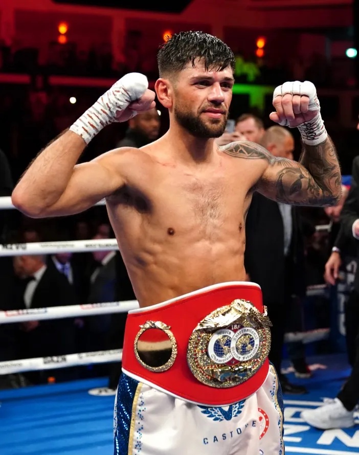 Joe Cordina celebrating in the boxing ring with his championship belt.