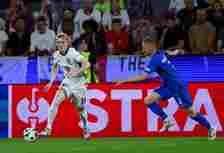 Anthony Gordon of England runs with the ball under pressure from Zan Karnicnik of Slovenia during the UEFA EURO 2024 group stage match between Engl...