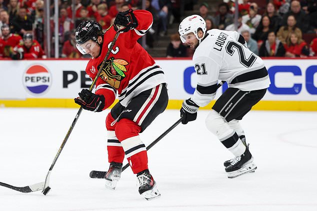 Chicago Blackhawks center Connor Bedard, left, and Los Angeles Kings center Scott Laughton (21) battle for the puck during the second period of an NHL hockey game, Tuesday, Oct. 27, 2026, in Chicago. (AP Photo/Jessie Alcheh)