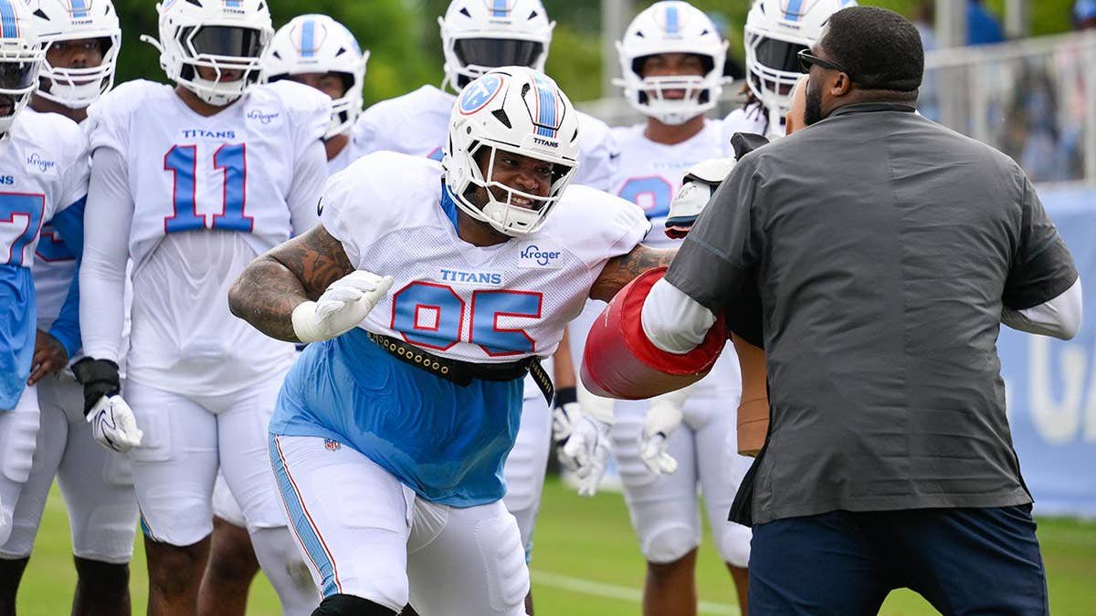 Jordan Elliott goes through drills during Titans training camp