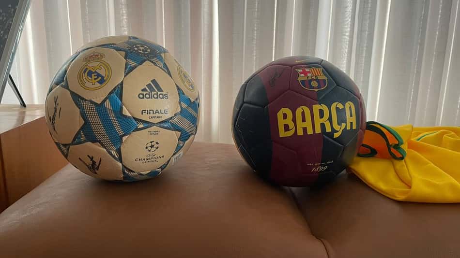 Evaristo Macedo El Clásico: Real Madrid x Barça com bolas oficiais ao lado.