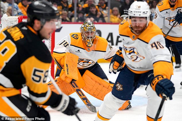 Nashville Predators goaltender Juuse Saros, center, watches as Pittsburgh Penguins' Kris Letang (58) is defended by Predators' Nick Perbix (48) during the second period of an NHL hockey game in Pittsburgh, Saturday, Oct. 24, 2026. (AP Photo/Gene J. Puskar)