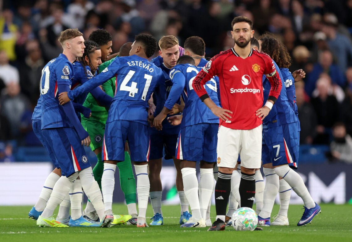 The Chelsea team huddle as Bruno Fernandes of Manchester United looks on prior to kick off