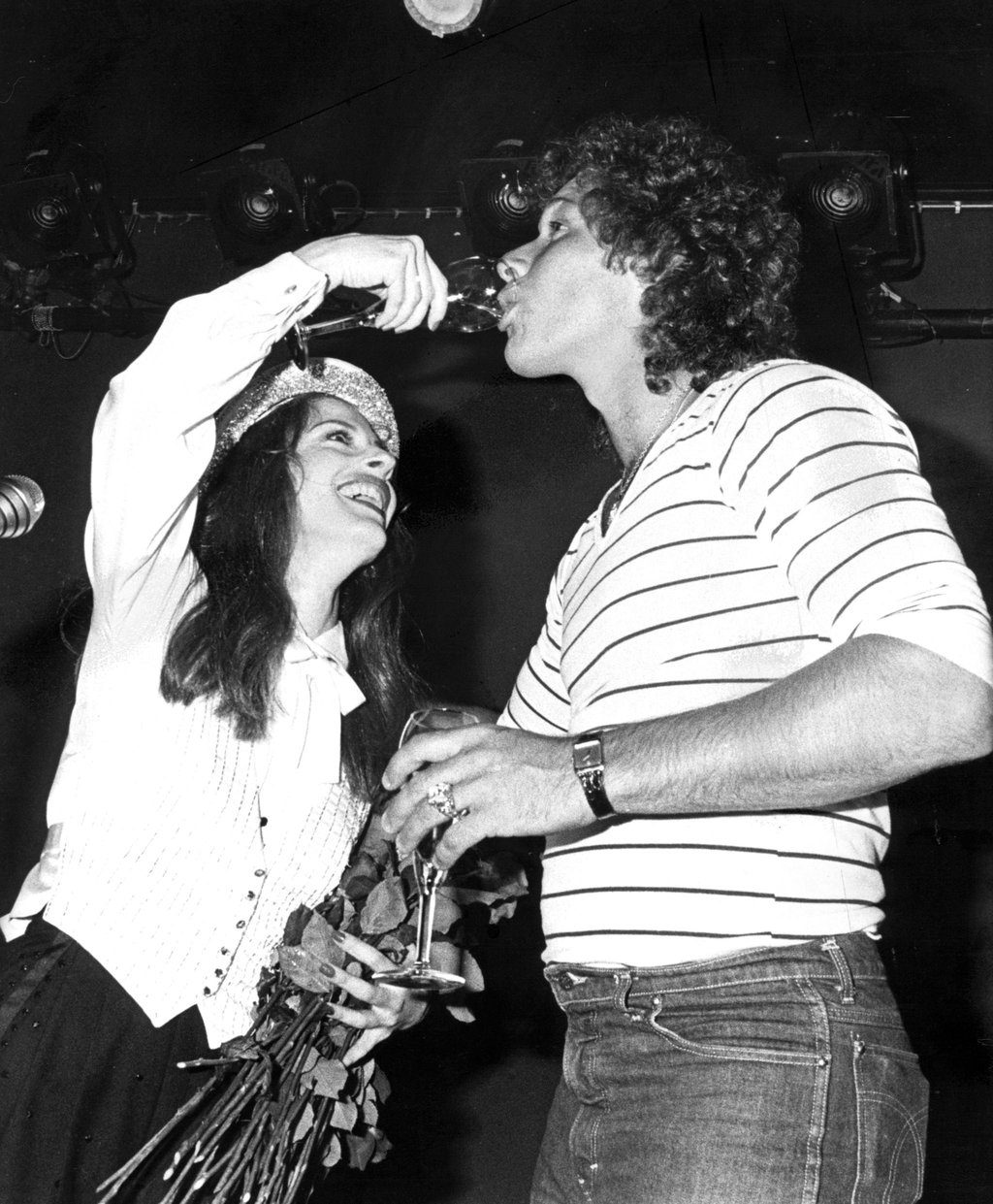 Patti LuPone gives Ron Duguay a sip from a glass.