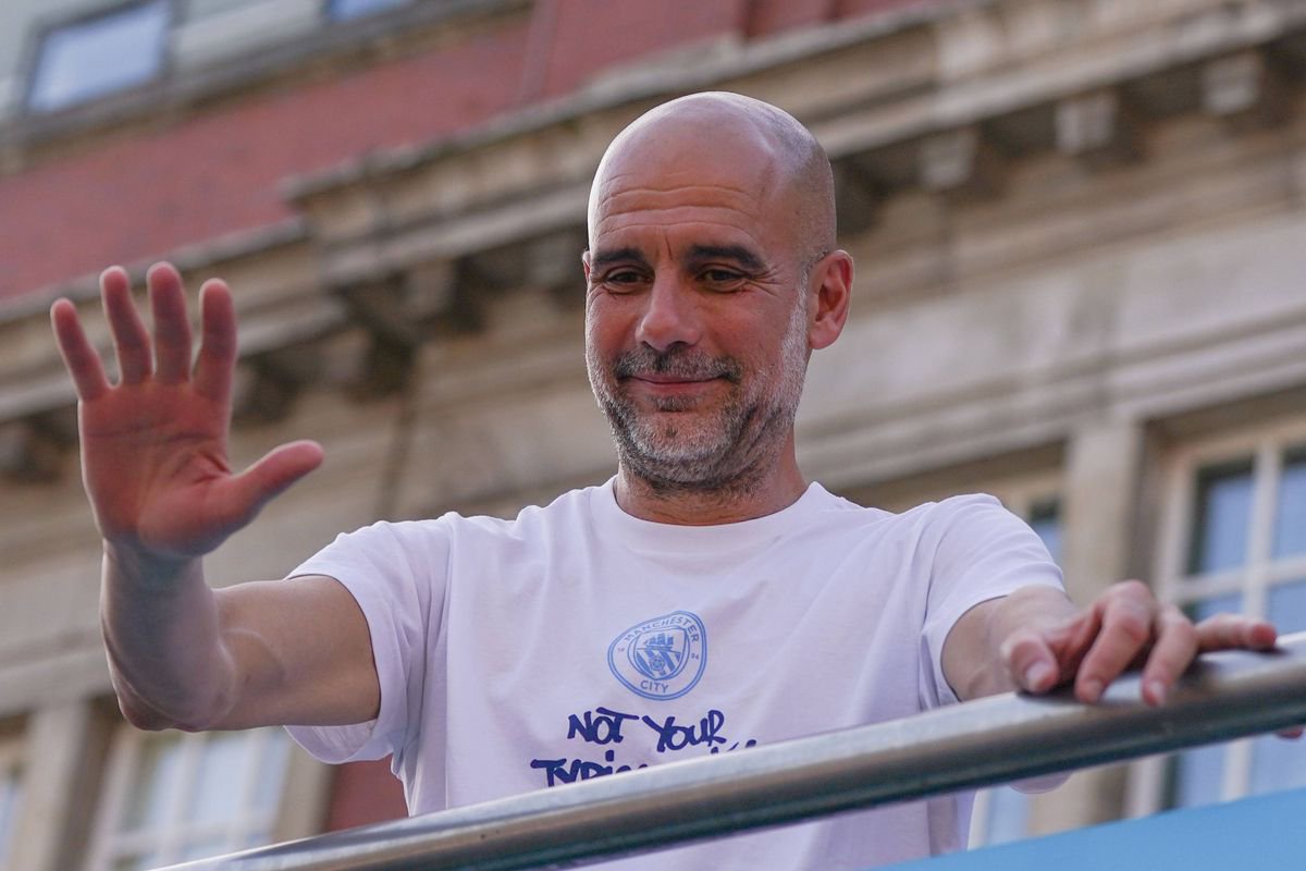 Pep Guardiola waving from an open-top bus