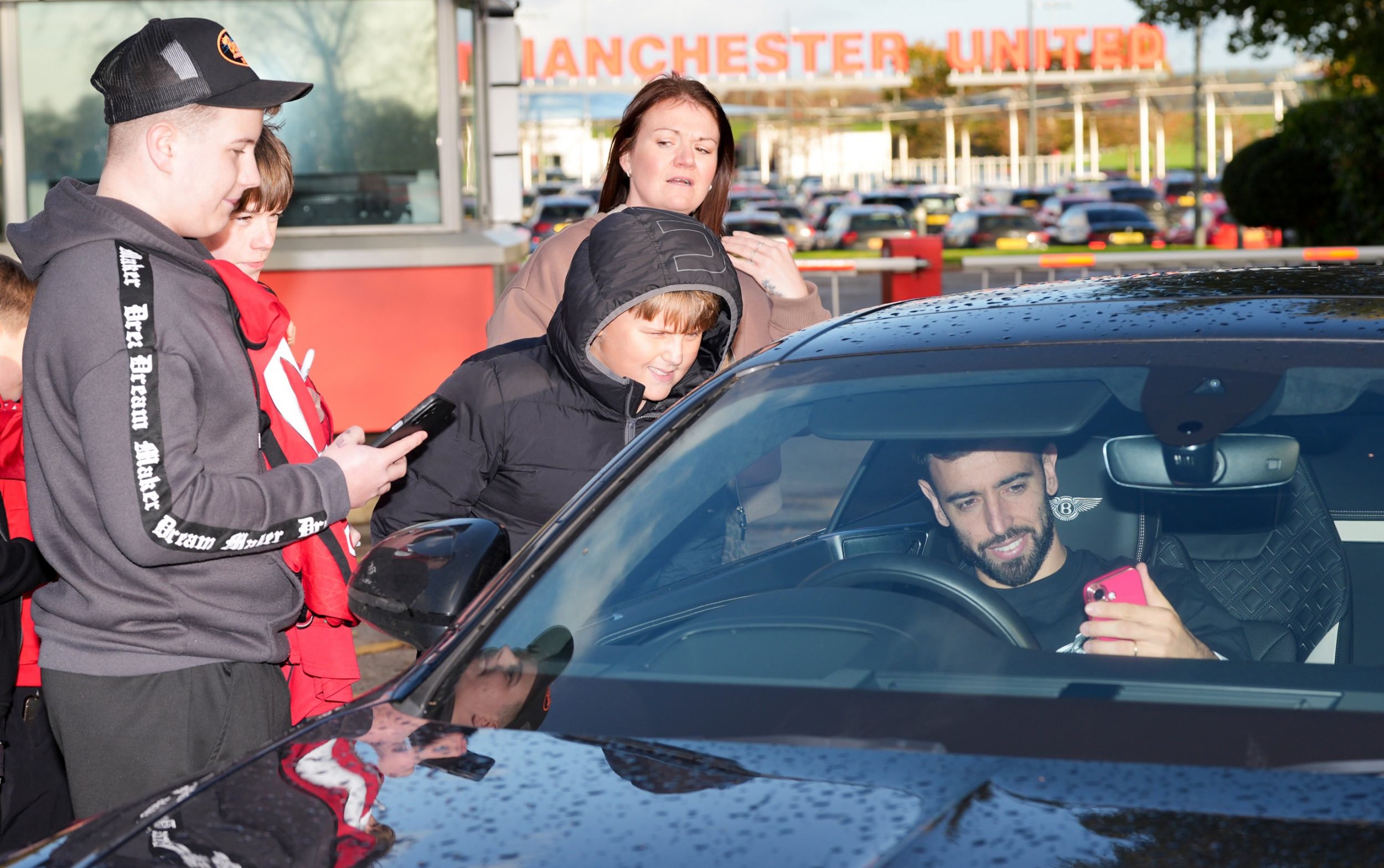 Bruno Fernandes takes selfies with fans as he leaves Carrington
