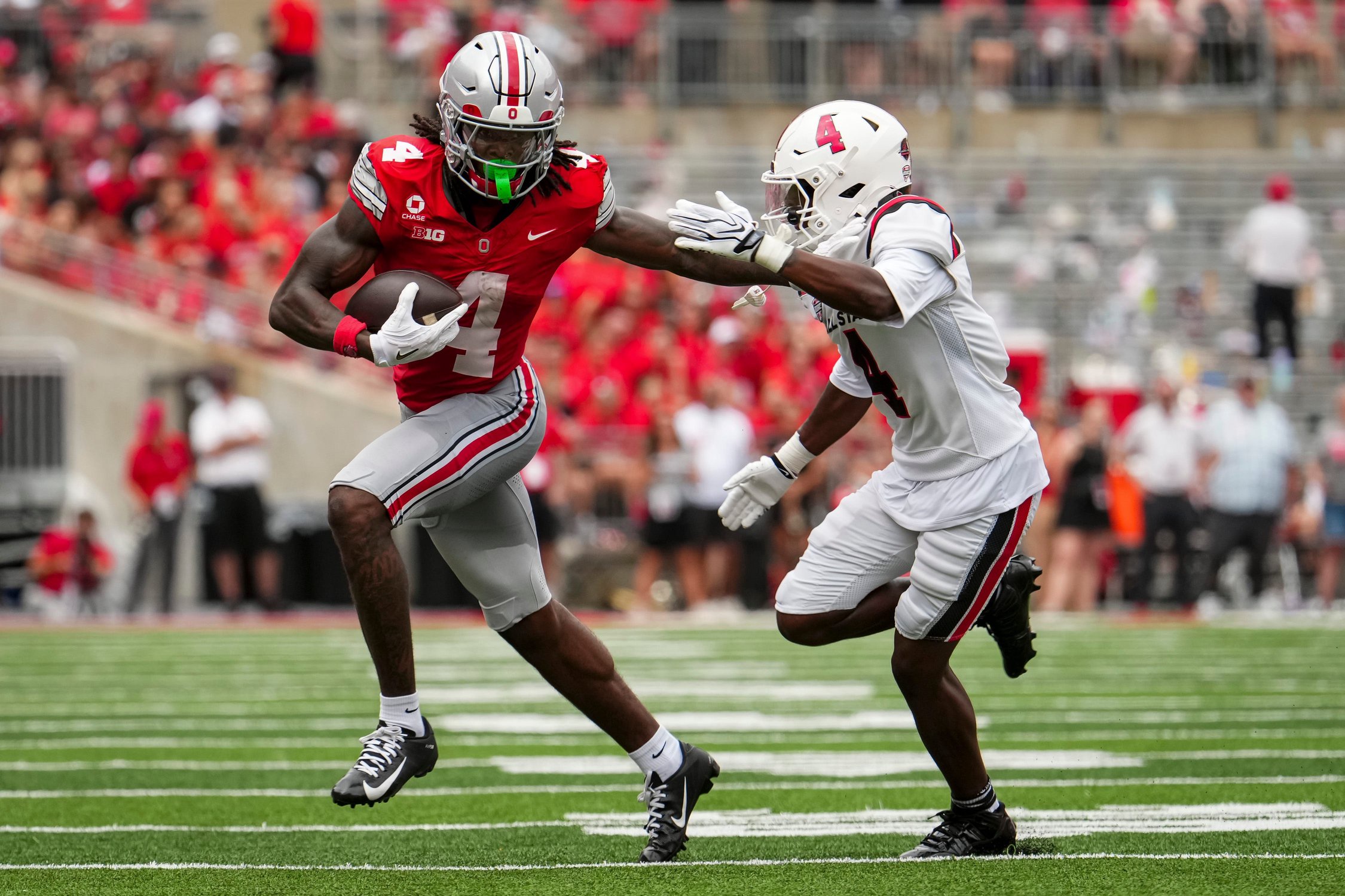 Ohio State Buckeyes wide receiver Jeremiah Smith (4) runs past Ball State Cardinals defensive back Willizhuan Yates (4) during the NCAA football game at Ohio Stadium in Columbus on Sept. 5, 2026.