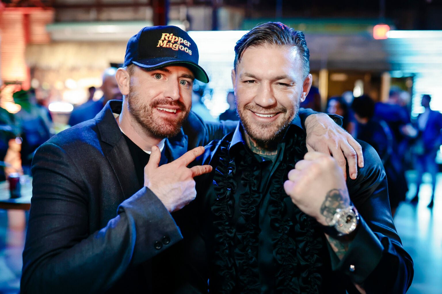 Bob Menery - wearing a hat that reads 'Ripper Magoos' - poses with Conor McGregor at a film premiere