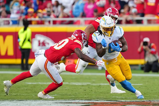 Los Angeles Chargers running back Omarion Hampton (8) gains yards after a catch as Kansas City Chiefs cornerback Chris Roland-Wallace, left, moves in to make the stop during the second half of an NFL football game in Kansas City, Mo., Sunday, Oct. 18, 2026. (AP Photo/Ed Zurga)