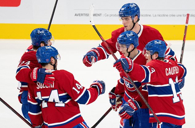 Montreal Canadiens' Lane Hutson, center right, celebrates his goal over the Buffalo Sabres with teammates Phillip Danault (24), Nick Suzuki (14), Juraj Slafkovsky (20) and Cole Caufield (13) during the first period of an NHL hockey game in Montreal on Tuesday, Oct. 13, 2026. (Christinne Muschi/The Canadian Press via AP)