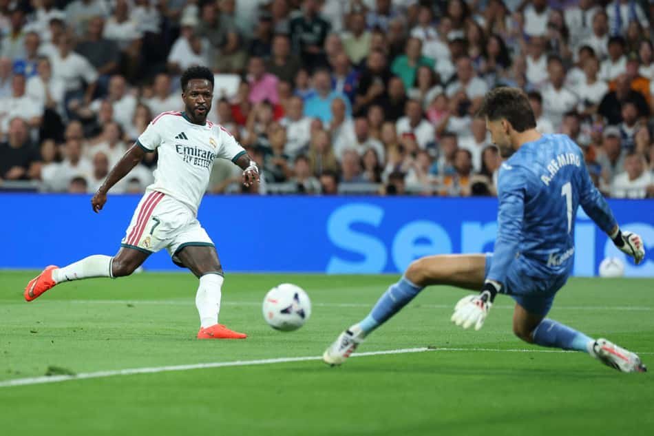 Vinicius Jr. tenta vencer o goleiro Alex Remiro no duelo entre Real Madrid e Real Sociedad