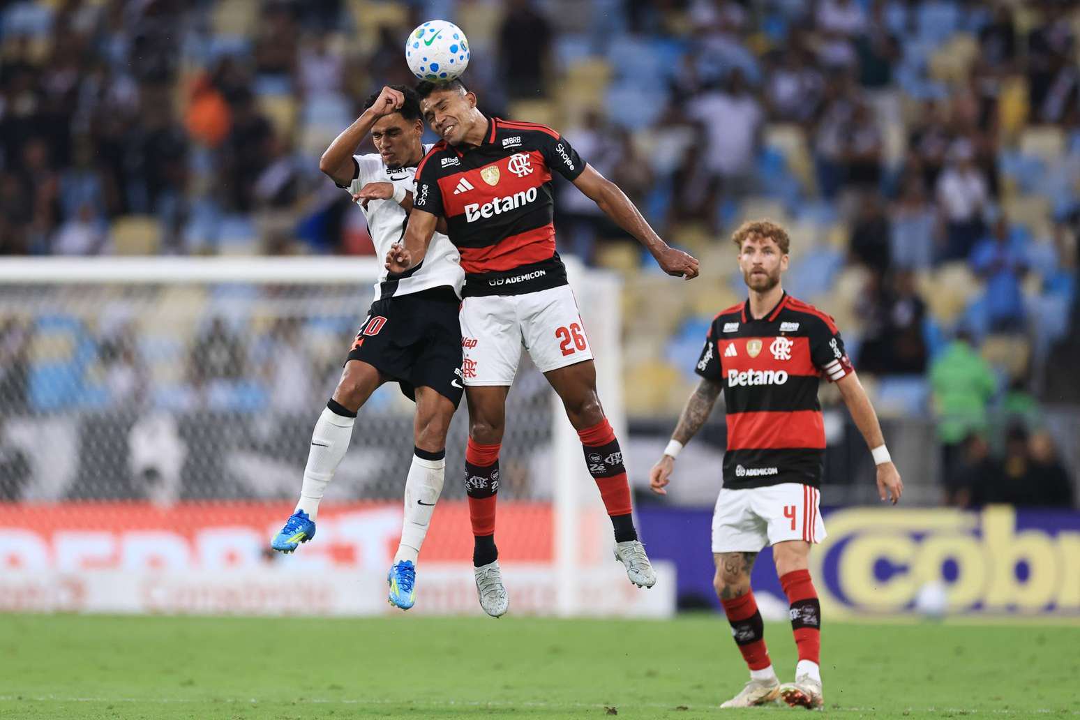 Alex Sandro, do Flamengo, e Brenner, do Vasco, disputam bola, enquanto Léo Pereira observa, na partida entre Flamengo e Vasco no primeiro turno do Campeonato Brasileiro de 2026 - 