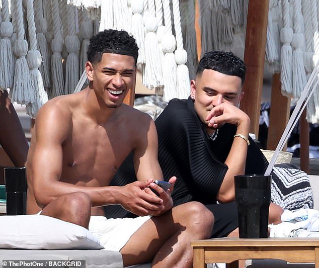 Good times: Jude looked happier than ever as he flashed a wide smile while chatting with his pals as they soaked up the sunshine