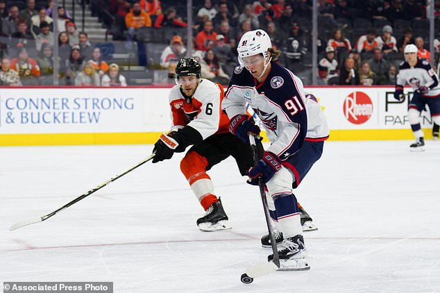 Columbus Blue Jackets' Kent Johnson (91) skates the puck past Philadelphia Flyers' Travis Sanheim during the third period of an NHL hockey game, Tuesday, Oct. 27, 2026, in Philadelphia. (AP Photo/Derik Hamilton)
