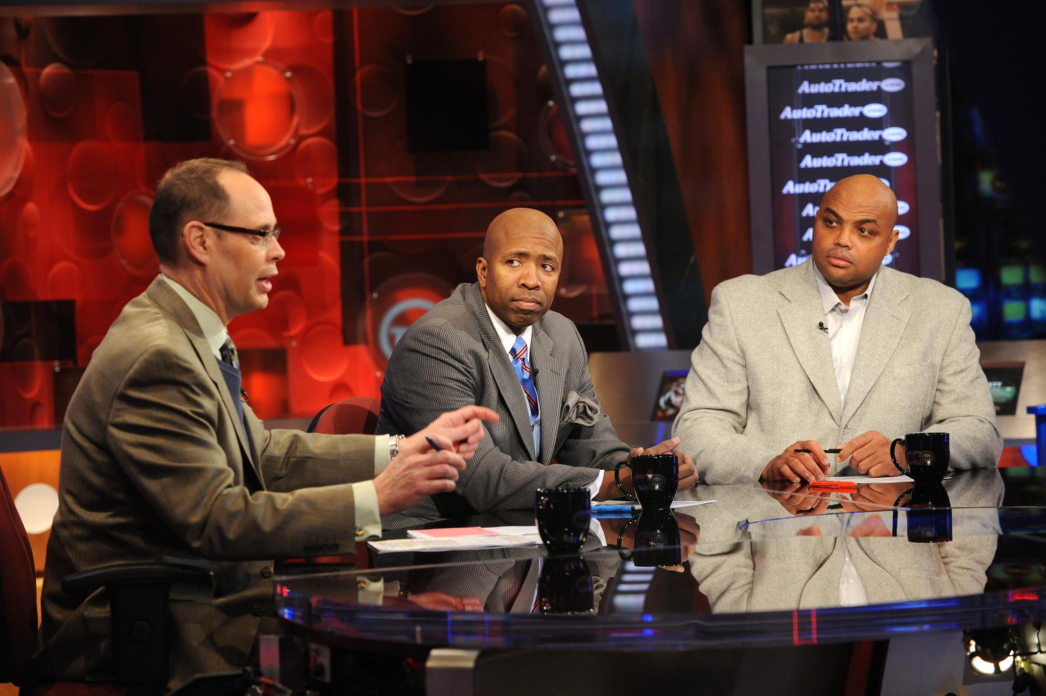 Inside the NBA host Ernie Johnson Jr., left, and analysts Kenny Smith, center, and Charles Barkley sit on set at the TNT studios.