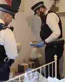 Officers can be seen flicking through books and cupboards, explaining: 'People can hide things in all sorts of places'