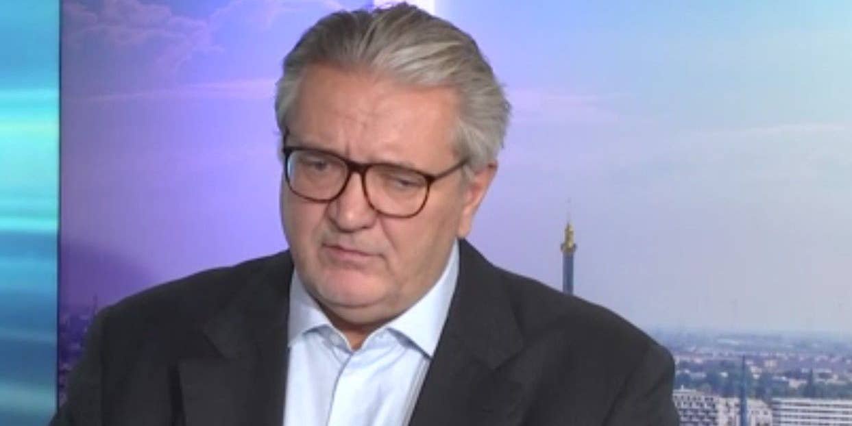 Ein Mann mit Brille und grauen Haaren spricht in einem Fernsehstudio.