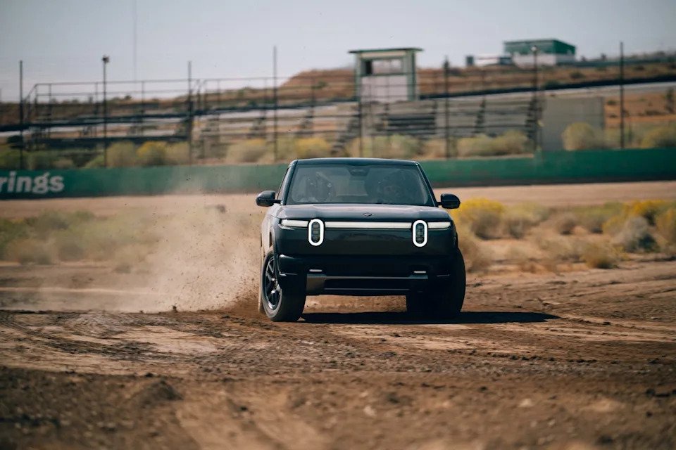 Electric vehicle kicking up dust on a dirt track, showcasing dynamic driving performance.