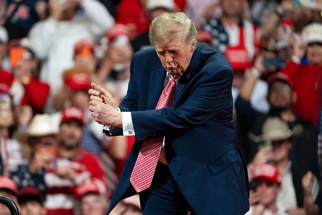 President Donald Trump imitates a golf swing after speaking at a campaign event in Park City, Kansas, US, on Monday, Oct. 19, 2026. (Nick Oxford/Bloomberg via Getty Images)