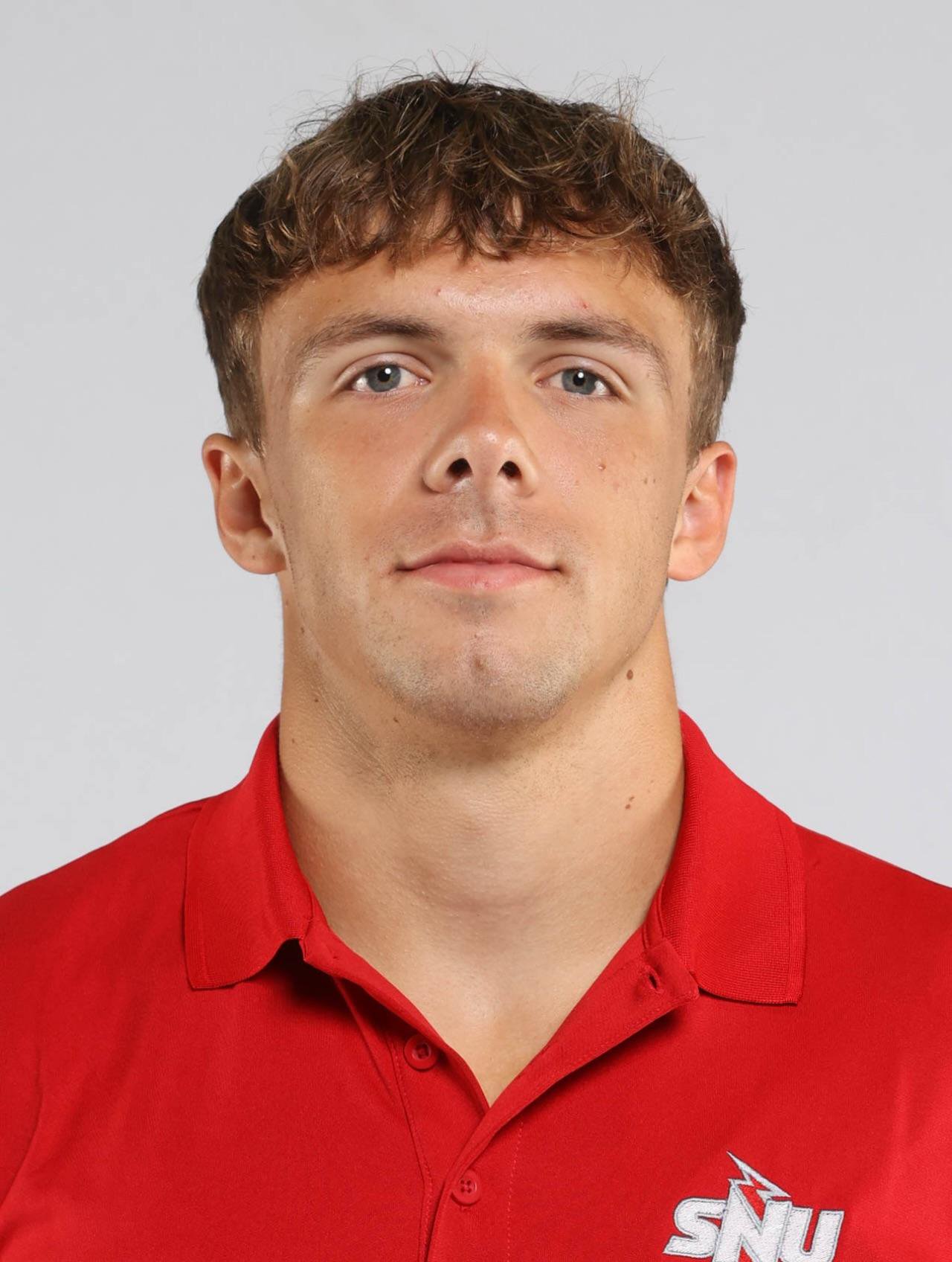 Portrait of college football player Tyler Ulrich in a red shirt.