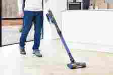 A man cleaning a wood floor with a Shark cordless vacuum cleaner