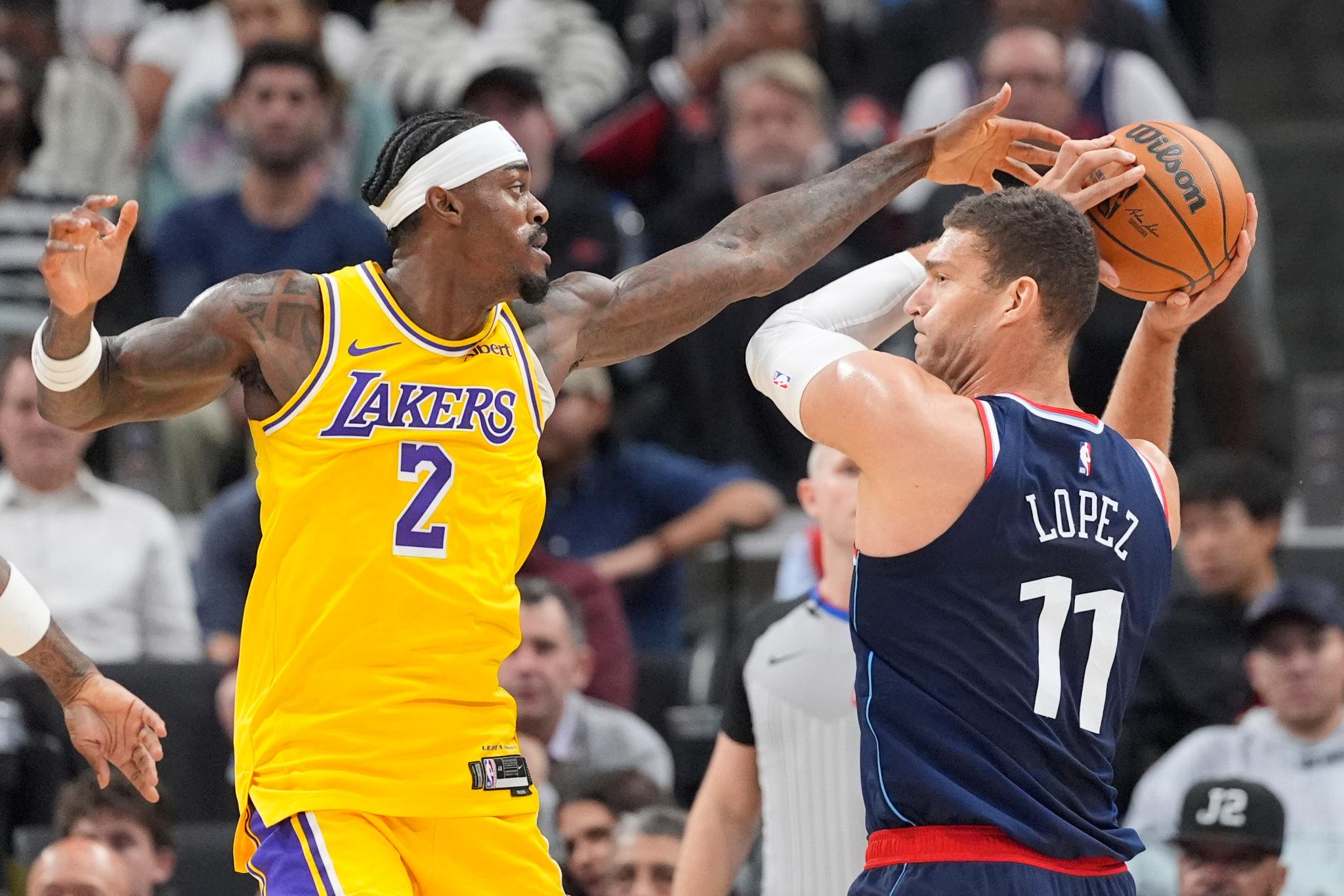 Los Angeles Clippers center Brook Lopez, right, passes under pressure from Los Angeles Lakers forward Jarred Vanderbilt on Wednesday, Oct. 28, 2026, in Inglewood, Calif.