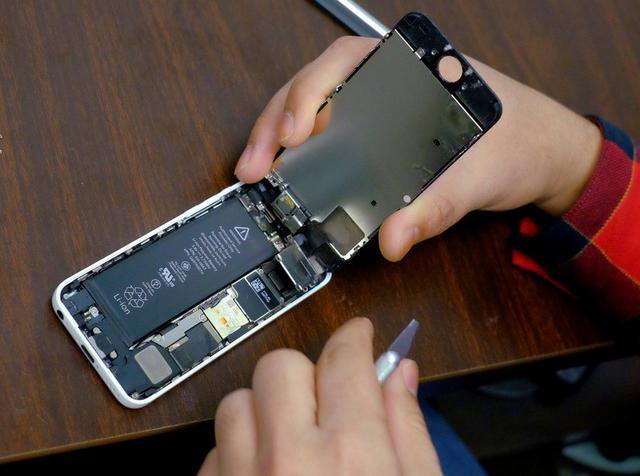 FILE PHOTO: A man tries to repair an iPhone in a repair store in New York