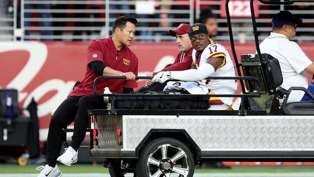Terry McLaurin is carted off the field during an NFL game.