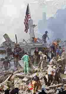 An American flag is stuck in the rubble of the World Trade Center as rescue workers search for survivors, September 13, 2001
